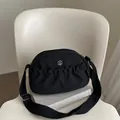 Minimalistische schwarze Nylon-Umhängetasche mit silbernem M-Logo und breitem Gurt - Schwarz