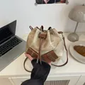 Brown corduroy drawstring bucket bag with leather trim and decorative pockets - White Without Charm