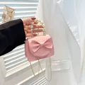 Pink mini crossbody bag featuring a large bow, pearl handle, and golden chain strap - Pink