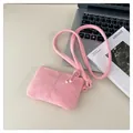 Mini-Umhängetasche in Rosa mit Wildledertextur neben einem Laptop auf einem Tisch - Rosa