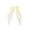 Detail van een crèmekleurige haarstrik van stof met lange elegante hangende linten - Beige
