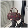 Close-up of tartan pattern texture and leather strap on this retro mini Boston bag - Red
