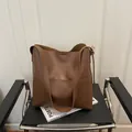 Minimalist large dark brown leather tote bag on black chair for daily commuting - Dark Brown