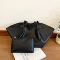 Grande borsa tote nera in ecopelle martellata con pochette coordinata e manico annodato - Nero