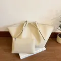 Dettaglio della borsa tote beige con ali, trama martellata e pochette interna con cerniera - Bianco Sporco