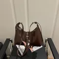 Deep brown glossy patent leather handbag with decorative silver rivets and buckle strap - Coffee