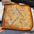 Flat lay of vintage paisley silk scarf with brown border on plush white background - LQ-14