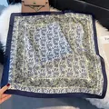 Detail of elegant paisley silk square scarf on plush rug with chic lifestyle accessories - LQ-17