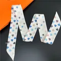 Detailansicht des schmalen Polyesterschals mit bunten Herzmustern in Schlangenform - Weiß