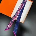 Nahaufnahme von doppelseitigem Blumen-Seidenschal mit orangefarbener Geschenkbox - 5x120cm / Blau