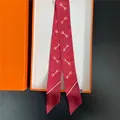 Twilly in seta rossa con motivo a morsetto dorato e cuori in confezione regalo arancione - Stile Morsetto Cuore Rosso Vino