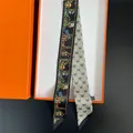 Dettaglio di un foulard in seta twilly double-face con fiori e cuori in una scatola regalo arancio - Stile Floreale Farfalla Cuore Doppia Faccia