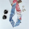 Detalle de un pañuelo estrecho de seda con estampado de paisaje vintage rojo y azul - Color 1 (Rojo y Azul)