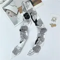 Elegant camellia floral silk twilly scarf for women styled with fashion accessories - White