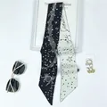 Macro detail of Cancer zodiac print on silk skinny scarf with moon and star patterns - Cancer