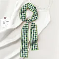 Detail of green argyle twilly scarf on white satin dress with aesthetic card prop - Green Navy White Argyle Style