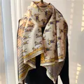 Detalle de un chal pashmina beige cálido con estampado de caballos azules y flecos - 180x65cm / Azul-Amarillo