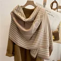 Detail view of a soft cashmere-like scarf with geometric patterns on a brown coat - Two-Tone Geometric Ring (FYR2203) / Violet