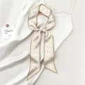 Elegante pañuelo de seda beige con estampado paisley anudado en un vestido blanco - Beige Paisley