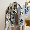 Détail d'une écharpe à losanges bleus en cachemire avec franges sur un manteau beige - Bleu Clair Noir