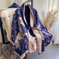 Close-up of navy blue scarf with pink floral patterns and delicate fringe details - Blue
