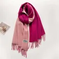 Primer plano de bufanda de cachemira rosa con borlas hechas a mano y etiqueta tejida - Light Pink and Rose Red