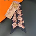 Close-up of double-sided silk twilly scarf with floral prints and washing instructions - Pattern 1 (Pink Champagne Floral)