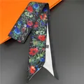 Floral silk twilly ribbon with red poppy print on black fabric next to gift box - Black