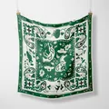 Detalle de un pañuelo de seda verde bosque y crema con motivos paisley y caballos - Verde bosque