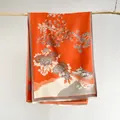 Detailansicht eines orangefarbenen Schals mit chinesischen Blumenmustern und Fransen - Orange