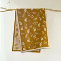 Detail of mustard yellow scarf with cute cat patterns and delicate fringe on wood branch - Yellow