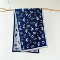 Detail of dark blue scarf with cat prints and fringe hanging on a wooden branch - Blue