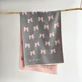 Dettaglio di sciarpa in maglia reversibile con motivo a fiocco rosa e grigio e frange - 185x65cm / Grigio rosato