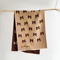 Close-up of beige bow-patterned scarf with white fringe tassels and soft cashmere texture - 185x65cm / Coffee