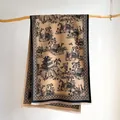 Detail of camel shawl featuring black landscape print and fringe hanging on a branch - 185x65cm / Black Coffee