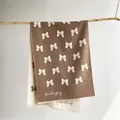 Brown and cream double-sided knitted scarf with white bow patterns and brand logo - 185x65cm / Khaki