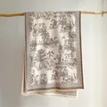 Dettaglio della sciarpa crema con motivi toile de jouy marroni e bordi a frange - 185x65cm / Kaki