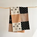 Detail of bee and polka dot pattern on a color-block thick faux cashmere scarf - 185x65cm / Black Camel