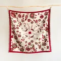 Detalle de bufanda cuadrada tejida con girasoles sobre base crema y flecos en color rojo - 130x130cm / Rojo Beige