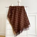Macro view of reversible brown cashmere-feel scarf with geometric pattern and fringe details - Coffee