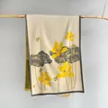 Detail of artistic lotus flower print and delicate frayed edges on a beige scarf - Beige