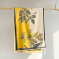 Détail d'une écharpe en cachemire à fleurs vintage avec glands sur cintre en bois - Jaune