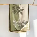 Détail d'un châle pashmina à fleurs avec franges fines sur un tissu vert olive - Vert