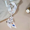 Elegante foulard di seta con motivo a catena annodato a una borsa con stile chic - Bianco