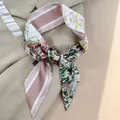Eleganter schmaler Seidenschal mit Tropenprint, als Knoten auf beigem Stoff gestylt - Rosa Grüner Tropischer Blumenstil (PD2525-1)