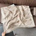 Detail of soft beige floral scarf with fringe edge on a premium leather background - Arranged Flower Khaki