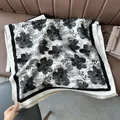 Close-up of black and white cashmere-like shawl with large floral print and fringe detail - Pear Flower Black