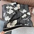 Detail of black cashmere-like scarf featuring white leaf patterns and fringe edges - Leaf-Black