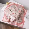 Elegant lily floral print silk scarf with pink edges displayed on marble surface - Pink