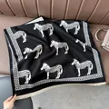 Thick knit zebra pattern scarf with beige tassels on a leather sofa - Zebra Black